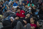 Migrants and refugees wait to be registered by police at the port of Mytilene, on the Greek island of Lesbos, early Sunday, Sept. 6, 2015.