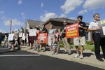 Protestors gather outside Dr. Walter James Palmer's dental office in Bloomington, Minn., Wednesday, July 29, 2015. Palmer reportedly paid $50,000 to track and kill Cecil, a black-maned lion, just outside Hwange National Park in Zimbabwe. (AP Photo/Ann Heisenfelt)