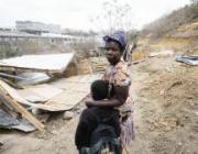 Martha Chofe & her son with the remains of her home, Cato Crest