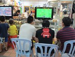 Obese teenagers were seen playing video game at a shop in Kuala Lumpur, Malaysia.