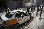 People inspect the site of a car bomb attack, claimed by the Islamic State, next to a Shiite mosque in Sanaa, Yemen, Thursday, Sept. 3, 2015.