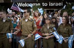 Israeli soldiers and relatives of new Jewish immigrants from the U.S. and Canada, wave Israeli flags to welcome them as they arrive at Ben Gurion airport near Tel Aviv, Israel, Tuesday, July 23, 2013.