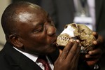 South Africa Deputy President Cyril Ramaphosa, kisses a reconstruction of Homo naledi's face during the announcement made at Maropeng Cradle of Humankind in Magaliesburg, South Africa, Thursday, Sept. 10, 2015.