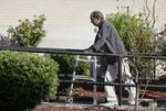 Sureshbhai Patel steadies himself with a walker as he arrives at the federal courthouse before start of a trial against Madison, Ala., police officer Eric Sloan Parker, Tuesday, Sept. 1, 2015, in Huntsville, Ala.