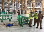 In this image released by the Saudi Interior Ministry’s General Directorate of Civil Defense, Civil Defense officials inspect the damage at the Grand Mosque in Mecca after a crane collapsed killing dozens, Friday, Sept. 11, 2015.