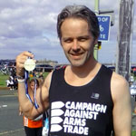 David Watson in a CAAT top holding a running medal