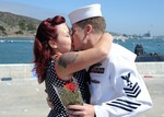 U.S. Navy Machinist's Mate 1st Class Douglas Boykin kisses his wife after returning to San Diego from a deployment aboard the Los Angeles-class attack submarine USS Albuquerque (SSN 706) Aug. 21, 2013.