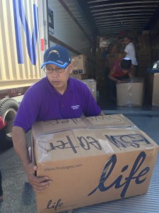 Patrick Cabrera loads boxes of donated items bound for the CNMI