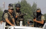 Commandos stand alert outside an air force base in Peshawar, Pakistan, Friday, Sept. 18, 2015.