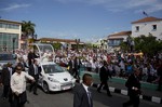 Security surrounds Pope Francis' popemobile as he greets residents as he makes his way to the Metropolitan Cathedral to celebrate Mass in Santiago de Cuba, Cuba, Tuesday, Sept. 22, 2015.