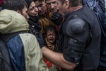 A Syrian refugee boy cries while he and his family try to board a train at the station in Tovarnik, Croatia, Sunday, Sept. 20, 2015.