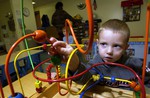 File - A child playing with a toy in a daycare. The Morale Welfare and Recreation Child Development Center on board Naval Support Activity Mid-South in Millington, Tenn. provides daycare services for dependent children ages six weeks to five years old of military personnel.