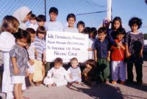 Children on Nauru with placard: We... request ... release ...from Nauru Cage