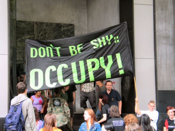 Banner at side entrance: Don't be Shy, Occupy!