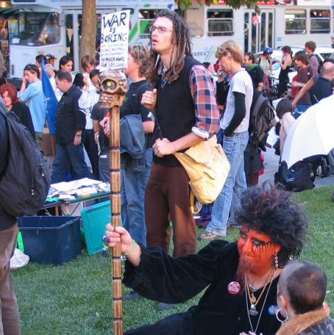 Man in heavy make-up with placard - War is Boring