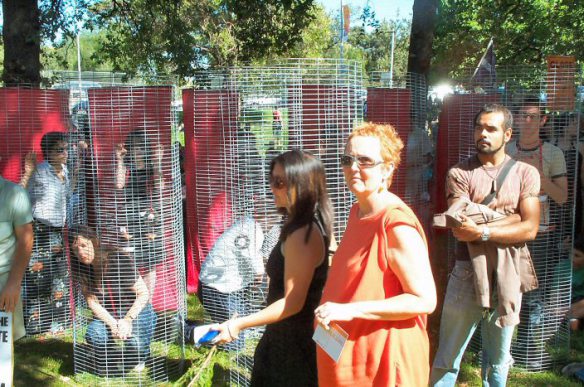 Wire cages with activists representing refugees