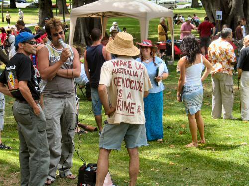 Media interview - man wearing t-shirt reading 'Wake up Australia, Genocide is a Crime'