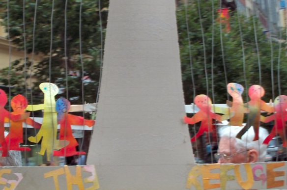 Closeup of dangling figures held by marcher in previous image