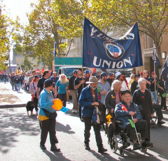 Older marchers helping unionist in wheelchair