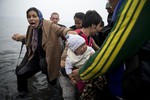 Migrants arrive on the shores of the Greek island of Lesbos after crossing the Aegean Sea from Turkey on an inflatable dinghy, Wednesday, Sept. 23, 2015.