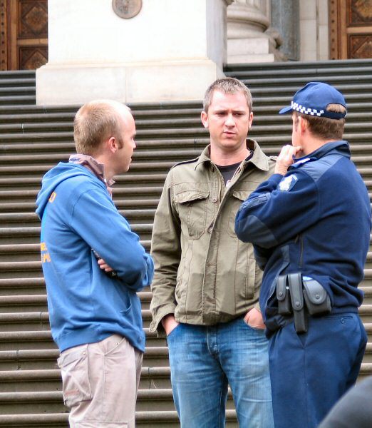 Undercover police talking to uniformed officer