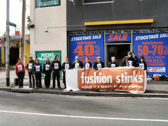 Protesters lineup with letters spelling 'End Sweatshops"