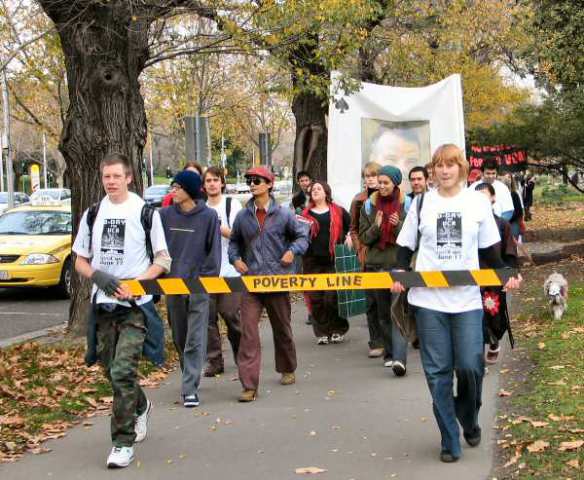 Students marching with 'poverty line'  - yellow tape