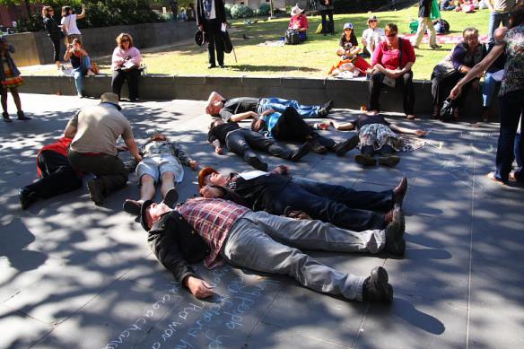 Activists lying on ground to simulate casualties