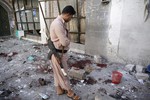 A Shiite fighter, known as a Houthi Police stands in the al-Balili mosque after two suicide bombings at the mosque during Eid al-Adha prayers in Sanaa, Yemen, Thursday, Sept. 24, 2015.