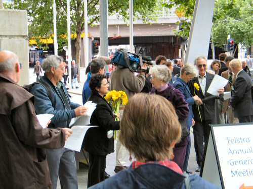 Protesters handing daffodils to shareholders on arrival