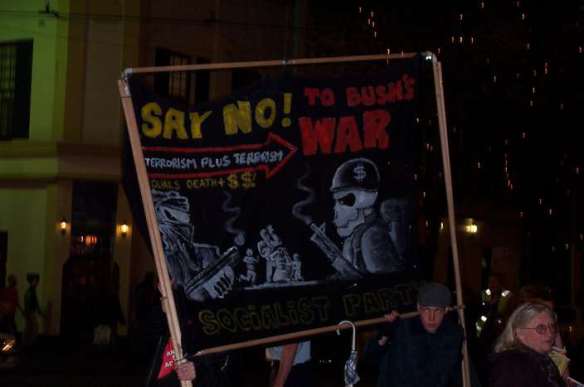 Placard reads "Say No to Bush's War"