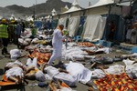 A muslim pilgrim walks through the site where dead bodies are gathered in Mina, Saudi Arabia during the annual hajj pilgrimage on Thursday, Sept. 24, 2015. Hundreds were killed and injured during a stampede.