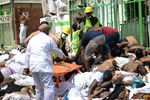 In this picture taken Thursday, Sept. 24, 2015, Muslim pilgrims and first responders gather around bodies of people crushed in Mina, Saudi Arabia during the annual hajj pilgrimage.