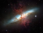 File - Plumes of glowing hydrogen blast from the center of M82, a well known galaxy undergoing a torrent of star formation.