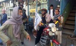 A Taliban fighter sits on his motorcycle adorned with a Taliban flag in a street in Kunduz city, north of Kabul, Afghanistan, Tuesday, Sept. 29, 2015.