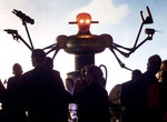 Visitors watch a six-armed robot move in a theme hall named 'Planet of Visions' on the opening day of the Expo 2000 World Exhibition in Hanover, northern Germany, Thursday, June 1, 2000. The Expo will be open every day from 09.00 to midnight until October 31, 2000.