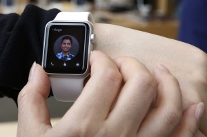 FILE - In this April 10, 2015, file photo, a customer tries on an Apple Watch at an Apple Store in Hong Kong. Although very few are dismissing the Apple Watch as a bomb, the mixed reviews underscore that Apple still has a lot of work to do in showing how the watch might fit in with everyday life. (AP Photo/Kin Cheung, File)