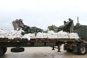 South Carolina National Guardsman from the 1052th Transportation Company cover a truckload of sandbags preparing to head out to one of several locations in S.C. at the Wateree Correctional Facility, Oct. 3, 2015 to prevent flooding in low-lying areas in the wake of Hurricane Joaquin.