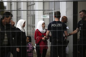 File - Refugees line up for registration at the temporary registration center of the southern German border town Passau, Tuesday, Sept. 15, 2015.