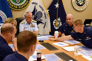 Rear Adm. Scott Buschman, commander of the Coast Guard 7th District, receives an update brief for the missing cargo ship El Faro at the Coast Guard 7th District in Miami, Saturday, Oct. 3, 2015.