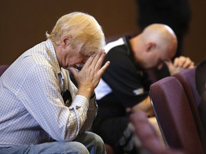 Parishioners bow their heads as they pray for the victims of the fatal shootings at Umpqua Community College during services at the Garden Valley Church in Roseburg, Ore., Sunday, Oct. 4, 2015.