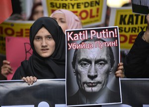 A demonstrator holds a picture depicting Russian President Vladimir Putin during a protest against Russian military operations in Syria, in Istanbul, Turkey, Saturday, Oct. 3, 2015. The picture reads both in Turkish and Russian: 'Murderer Putin'.