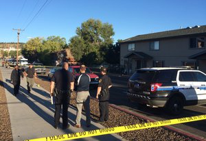 Authorities gather outside a student dormitory in Flagstaff, Ariz., Friday, Oct. 9, 2015, after an early morning fight between two groups of college students escalated into gunfire leaving one person dead and three others wounded, authorities said.