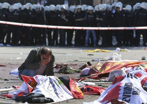 A man cries over the body of a victim, at the site of an explosion in Ankara, Turkey, Saturday, Oct. 10, 2015. The two bomb explosions targeting a peace rally in the capital Ankara have killed scores of people.