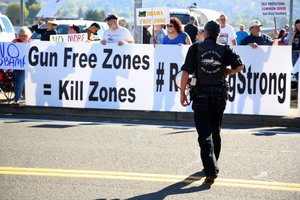 Demonstrators wait outside of Roseburg Regional Airport for President Barack Obama's arrival in Roseburg, Oregon, Friday, Oct. 9, 2015. Gun-rights activists say they plan to protest when Obama visits here Friday to meet with families of victims of last week's college shooting rampage.