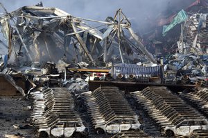 Charred remains of a warehouse and new cars are left over after an explosion at a warehouse in northeastern China's Tianjin municipality, Thursday, Aug. 13, 2015.  Huge explosions in the warehouse district sent up massive fireballs that turned the night sky into day in the Chinese port city of Tianjin, officials and witnesses said Thursday.  (AP Photo/Ng Han Guan)