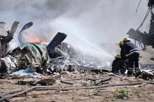 AMISOM firefighters attempt to stop the fire at the site of an airplane crash in Mogadishu, Somalia, on August 9. An Ethiopian Air Force aircraft crashed upon landing this morning at Mogadishu's Aden Adde International Airport. Two of the six crew members survived the crash. AU UN IST PHOTO / TOBIN JONES