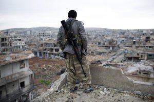 In this Jan. 30, 2015 file photo, a Syrian Kurdish sniper looks at the rubble in the Syrian city of Ain al-Arab, also known as Kobani.