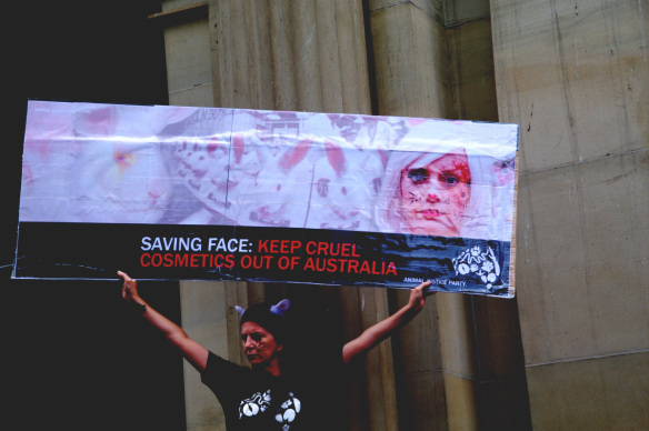 Protester holds placard with rabbits and blotched human face