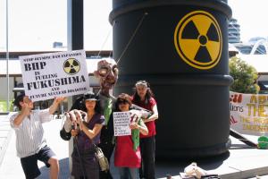 Members of Japanese for Peace next to barrel